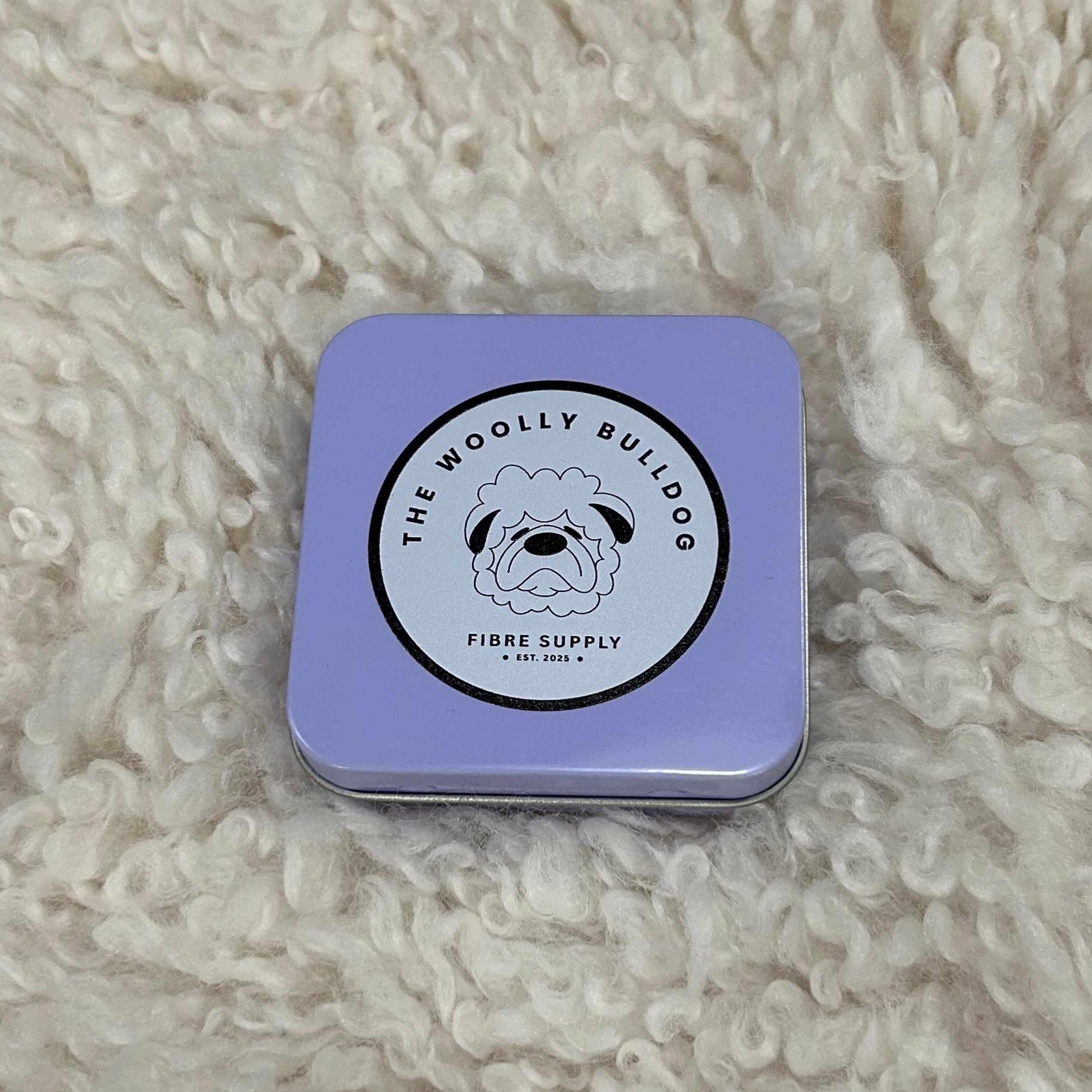 Purple tin with a logo on a textured beige surface