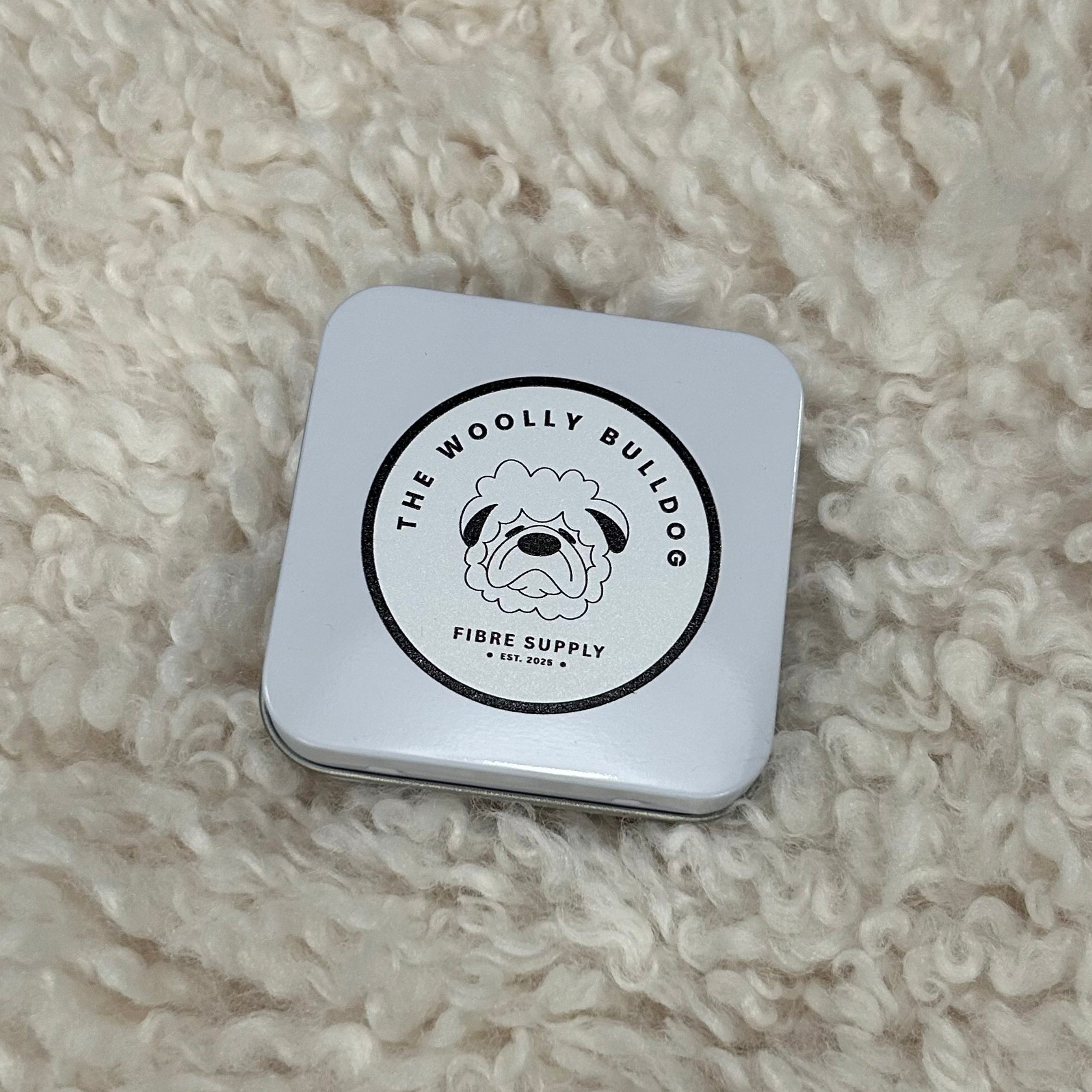 Square tin with a logo on a fluffy white surface