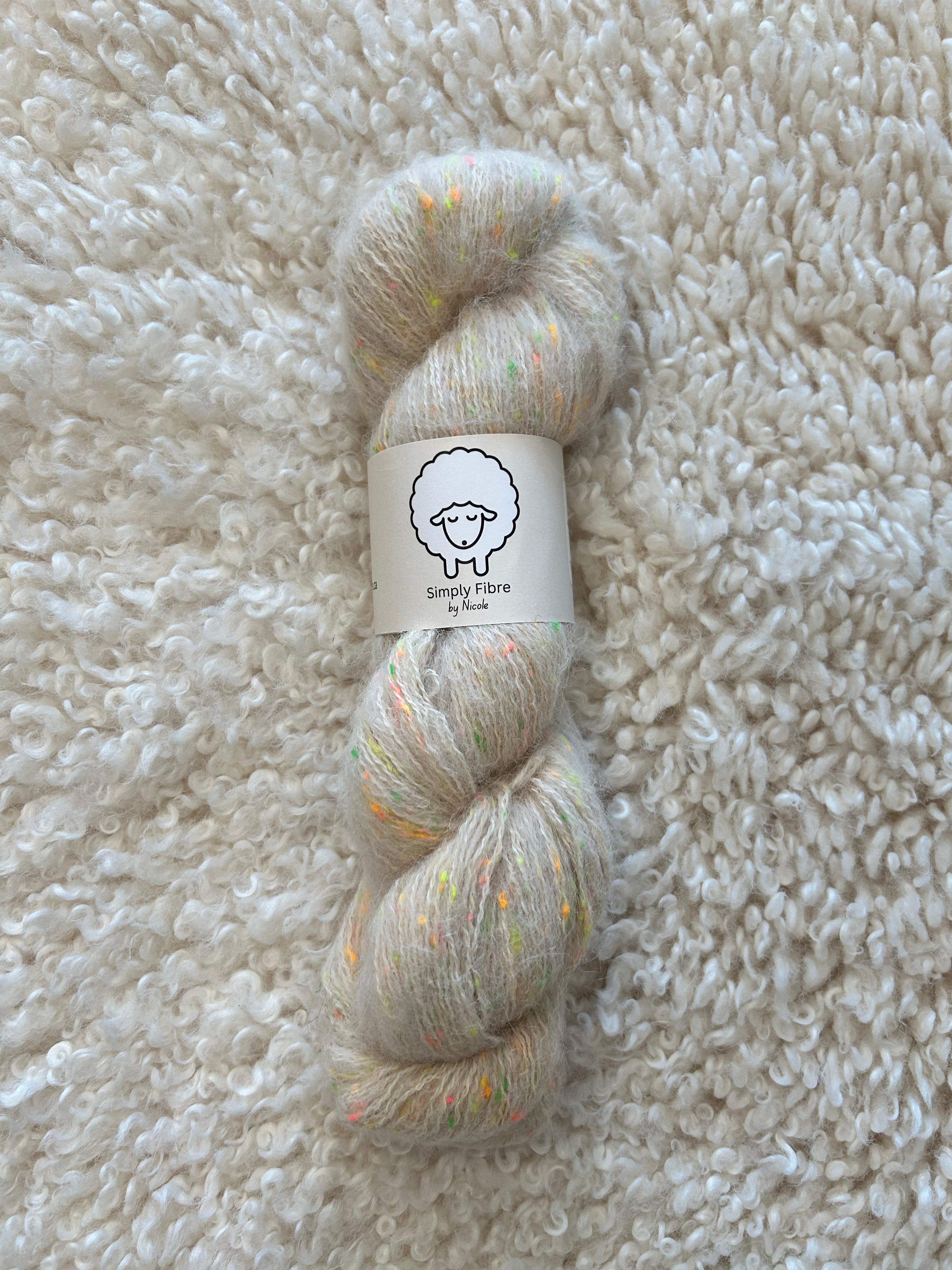 Skein of yarn with a label on a textured beige surface