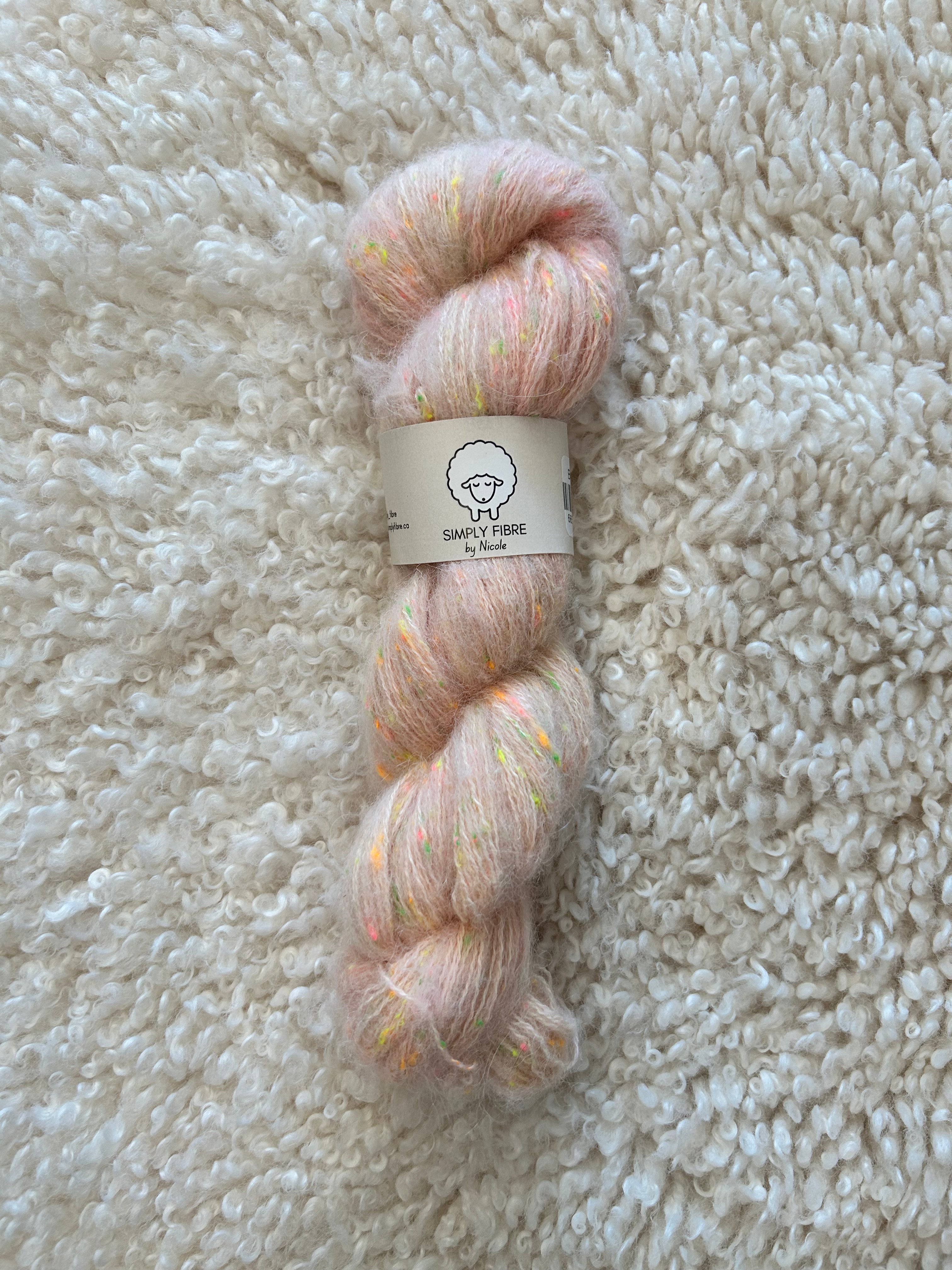 Yarn skein with a label on a textured beige surface