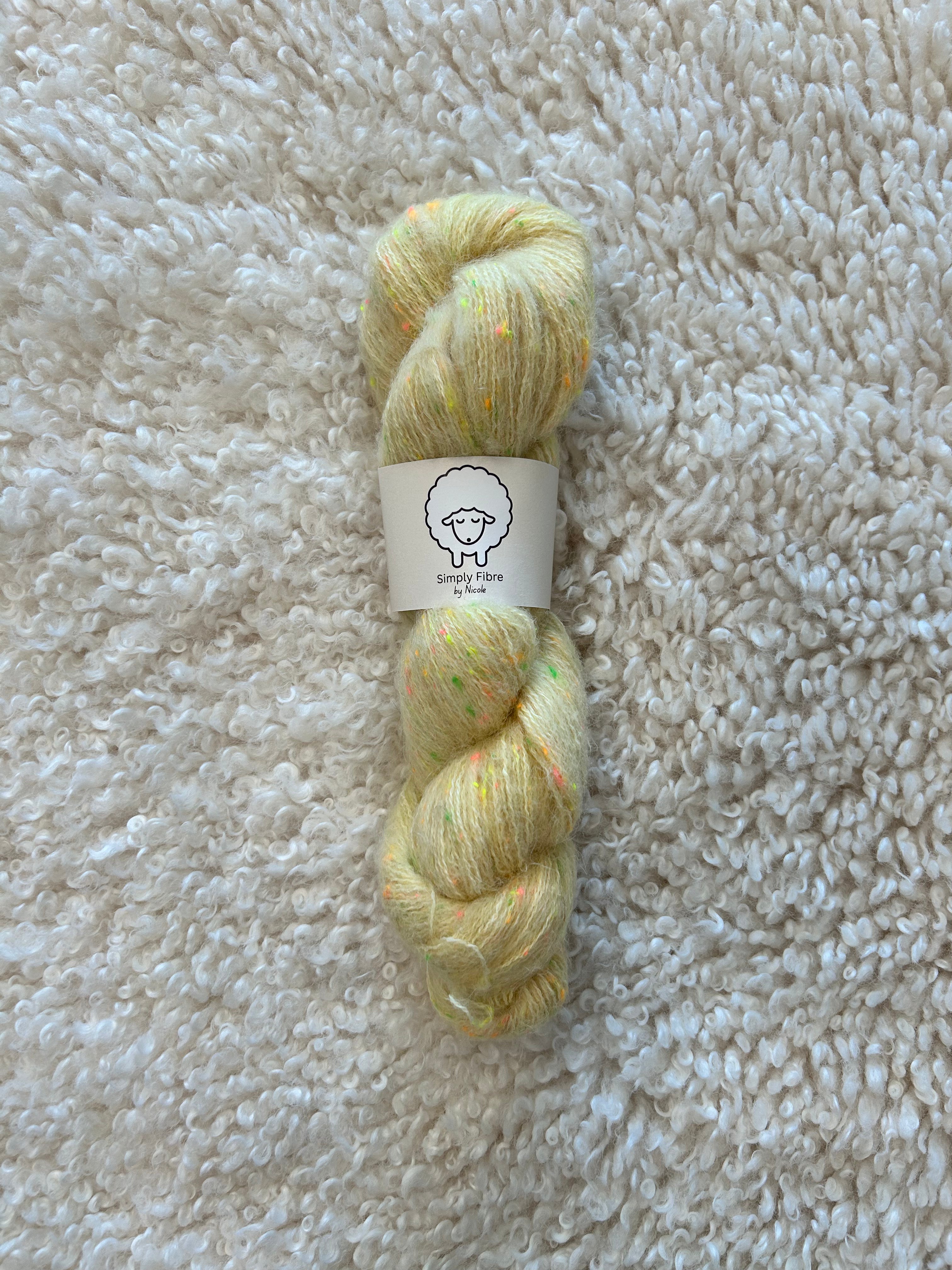 Yarn skein with a label on a textured beige surface