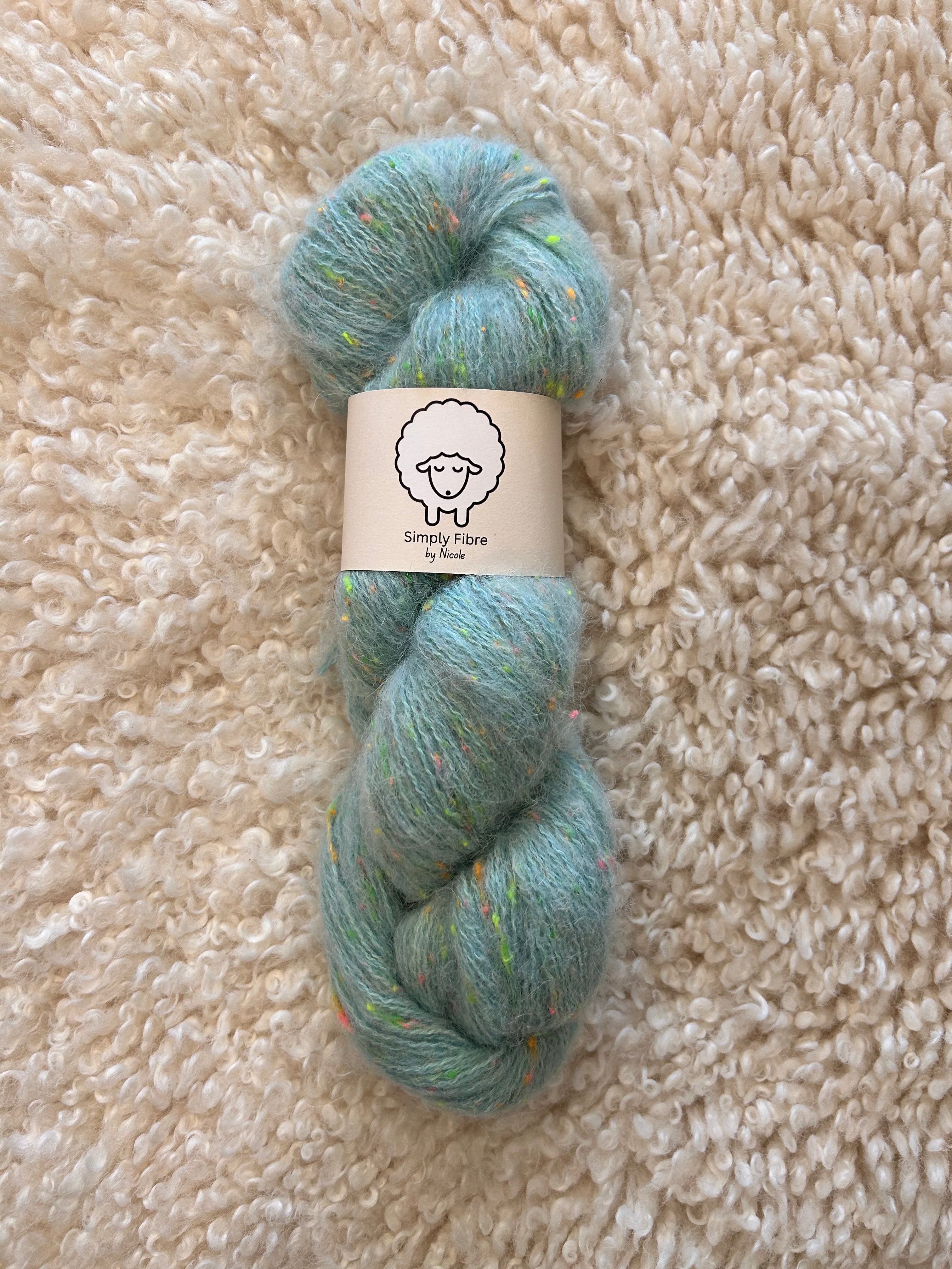 Blue skein of yarn with a label on a beige textured surface