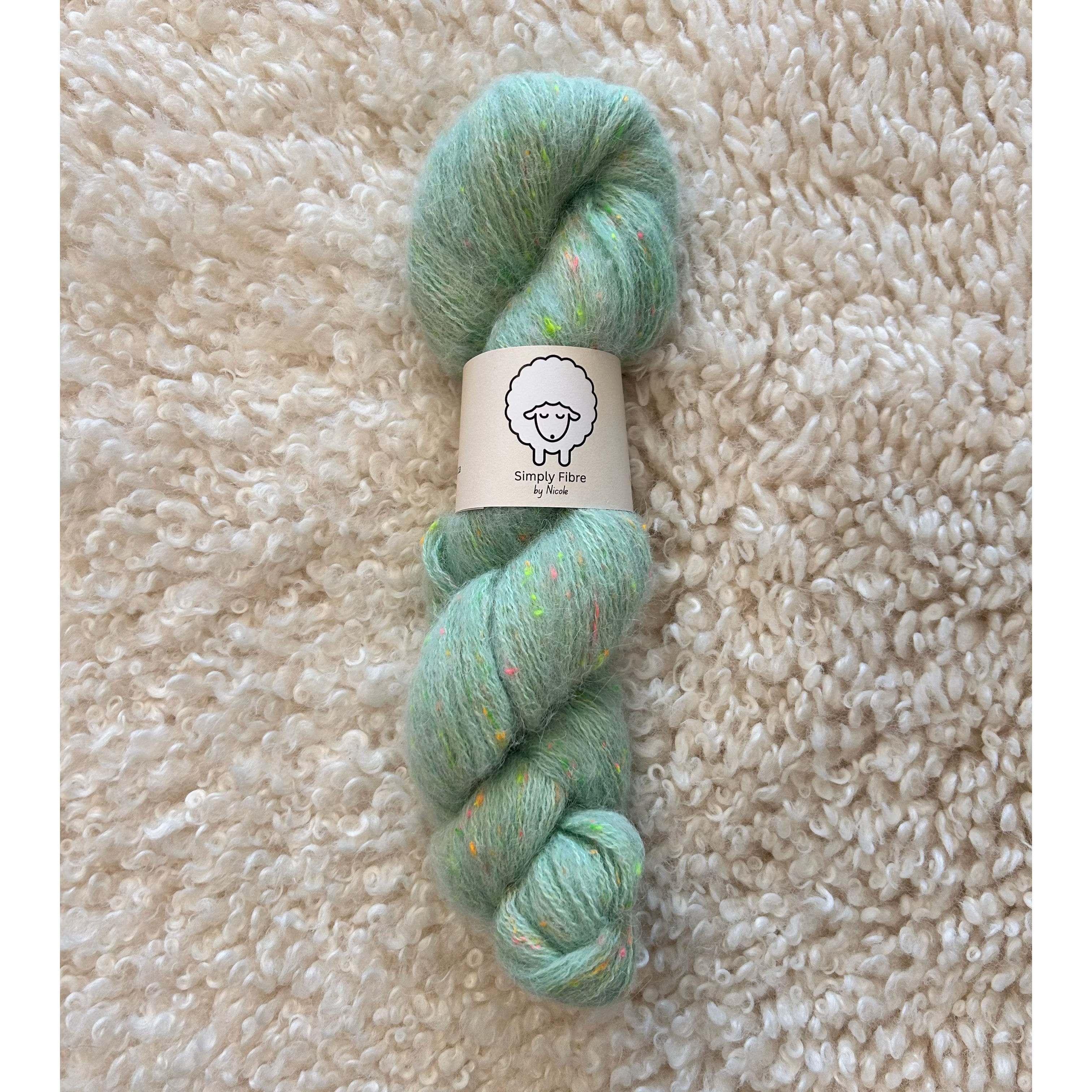 Green skein of yarn with a label on a beige textured surface