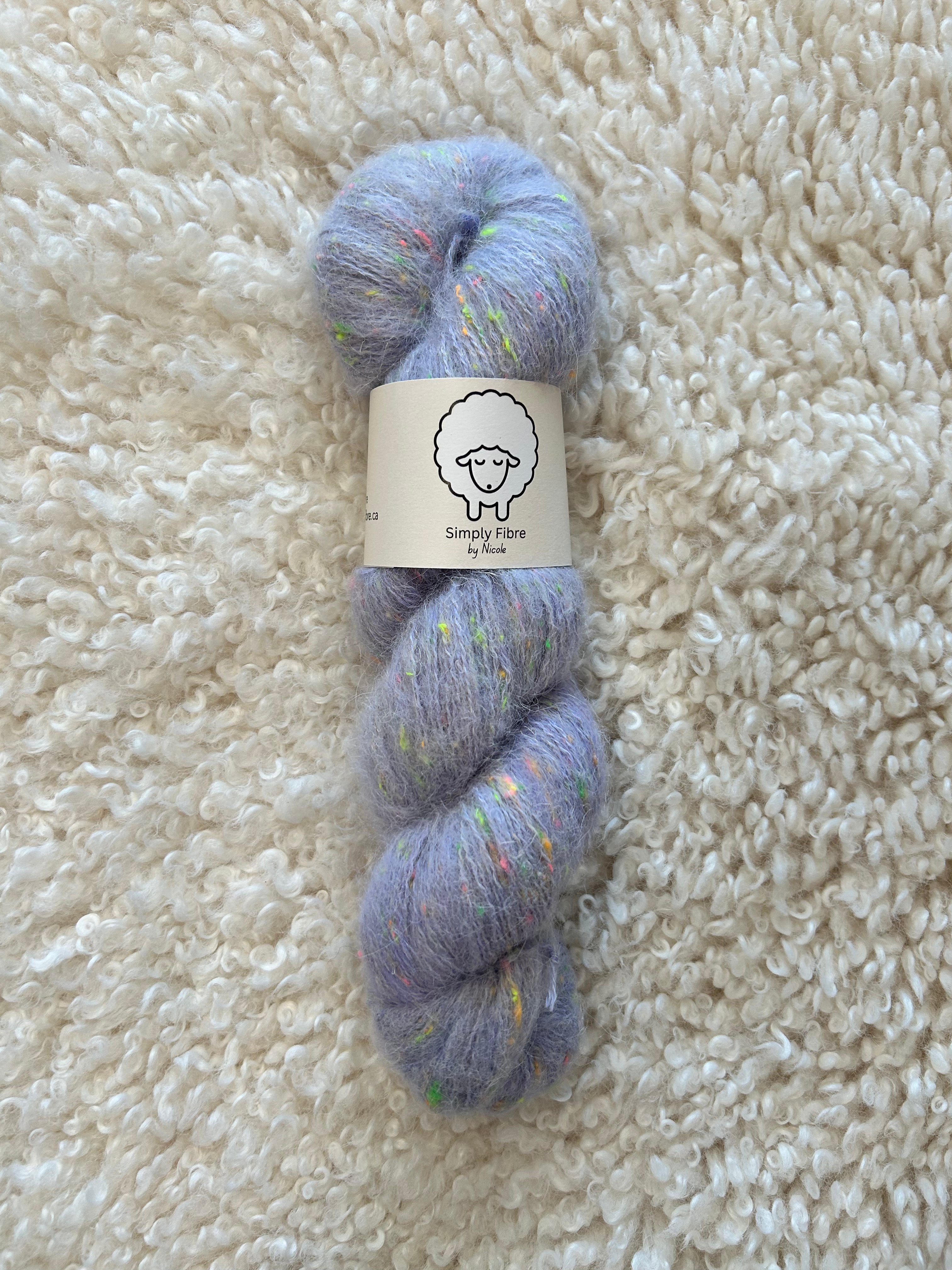 Blue skein of yarn with a label on a beige carpet